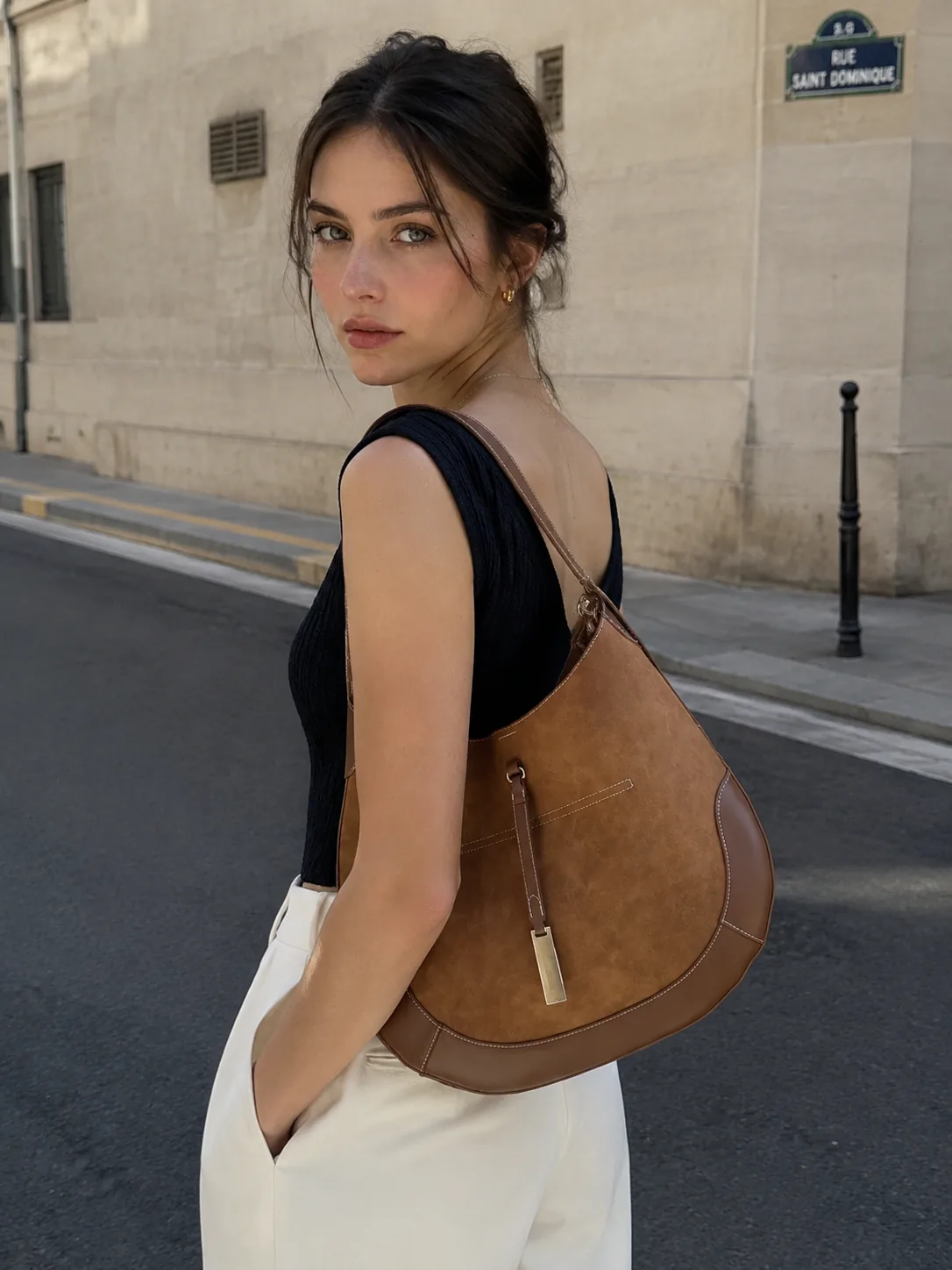Mira Curve Tote on the shoulder, walking a city street