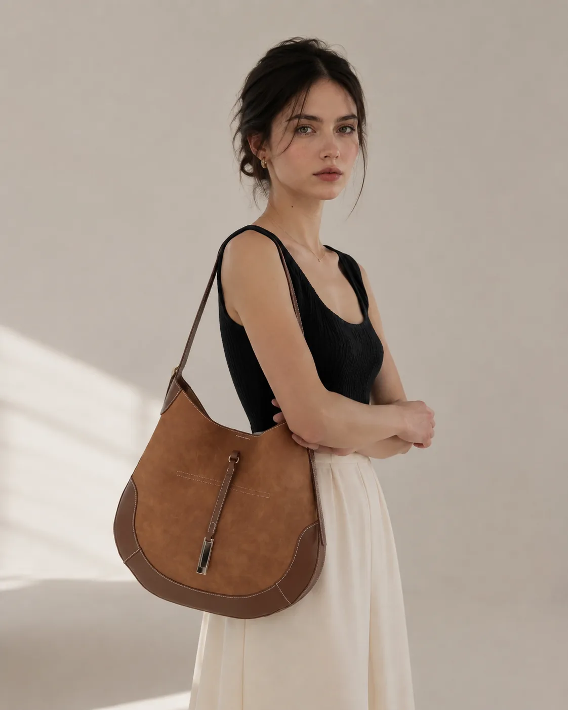 Black knit top with a long cream skirt, Mira on the shoulder