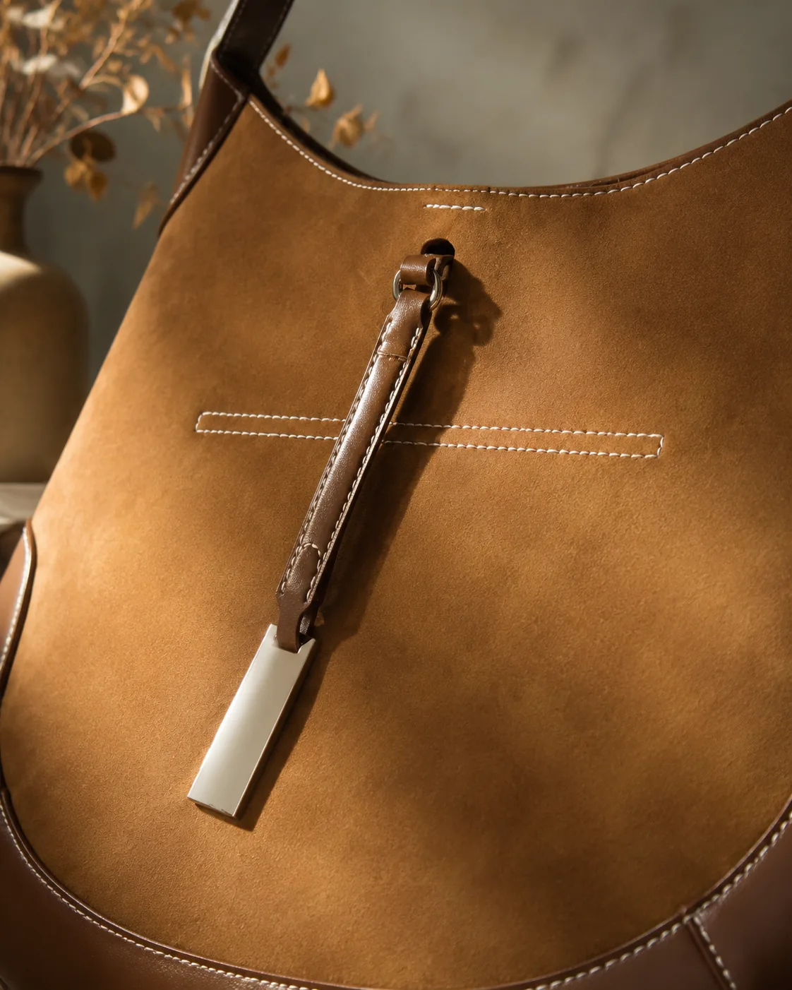 Gold-tone hardware and strap detail at the centre of the bag